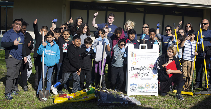 UC Merced Police Department officers, student mentors and Margaret Sheehy Elementary School students gather for a group photo during their beautification project. 